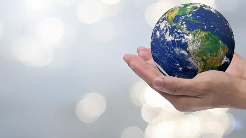 man hand gesture palm up holding world on blurred peaceful water surface background