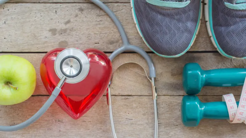 diet plan with sport shoes and bottle of water and Dumbell on wooden background