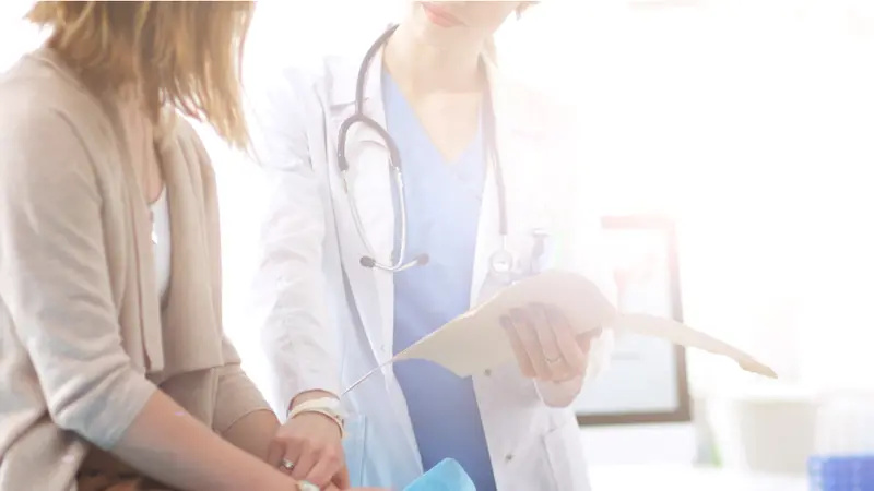 Doctor and patient discussing something while sitting at the table 