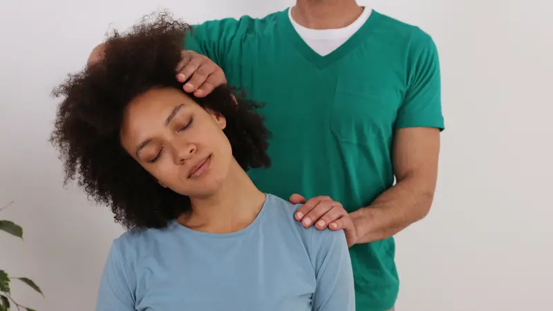 Woman having chiropractic back adjustment in rehabilitation clinic