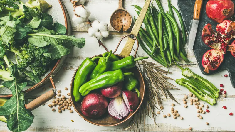 Flat-lay of vegetables, fruit, beans, cereals, kitchen utensil, dried flowers, olive oil over white wooden background, top view. 