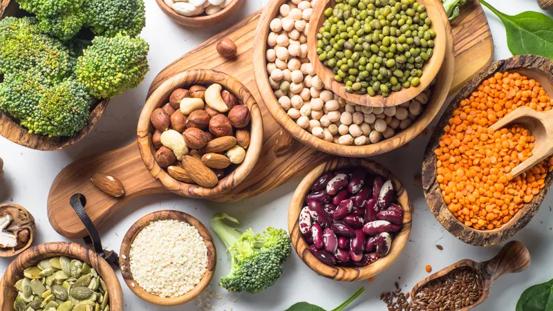 Vegan protein source. Beans, lentils, nuts, broccoli spinach and seeds. Top view on white table. Healthy vegetarian food.