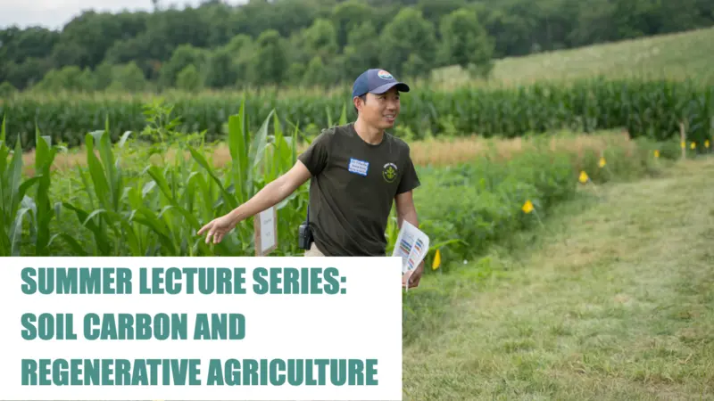 Rodale Institute Worker pointing to a field of crops 