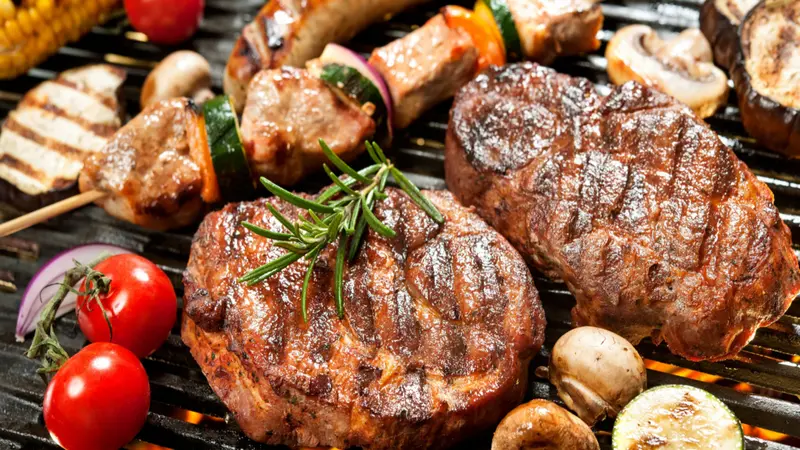 Assorted delicious grilled meat with vegetable over the coals on a barbecue