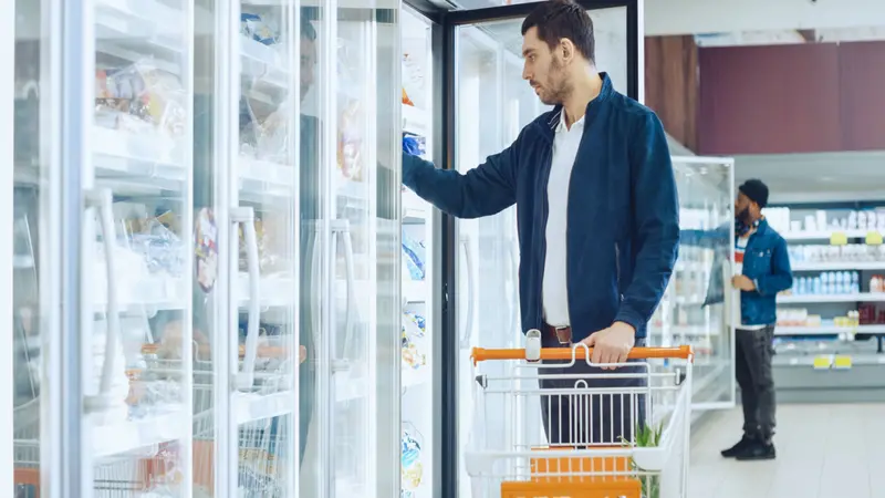 At the Supermarket, Men Browse for Products in the Frozen Goods Section