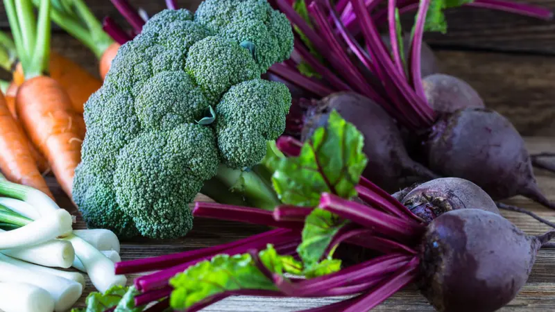 Fresh vegetables beetroots, broccoli, carrots, green onion on wooden background