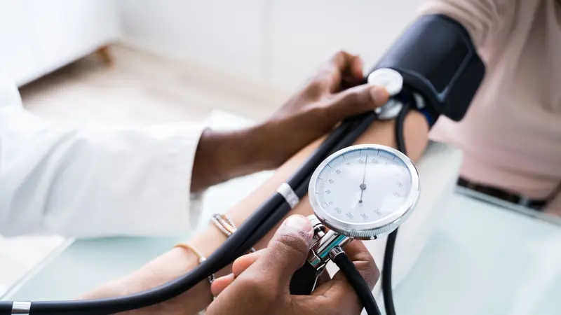 Close-up Of Doctor Measuring Patients Blood Pressure With Stethoscope