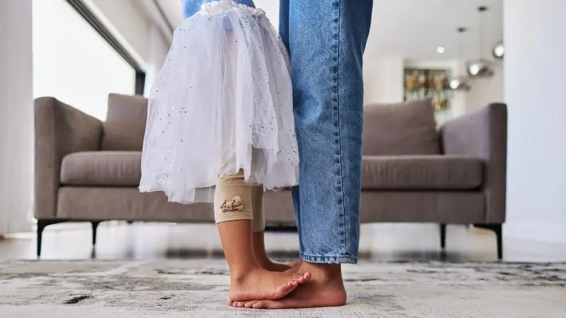 Mother dancing with daughter standing on her feet