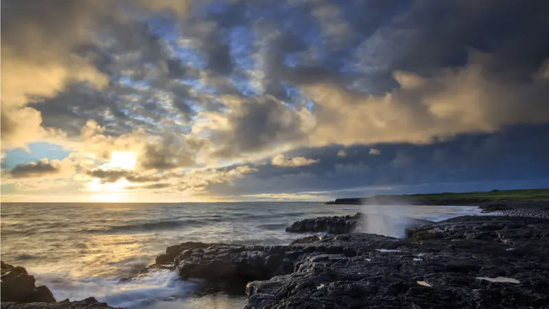 A rocky ocean shore of during sunset