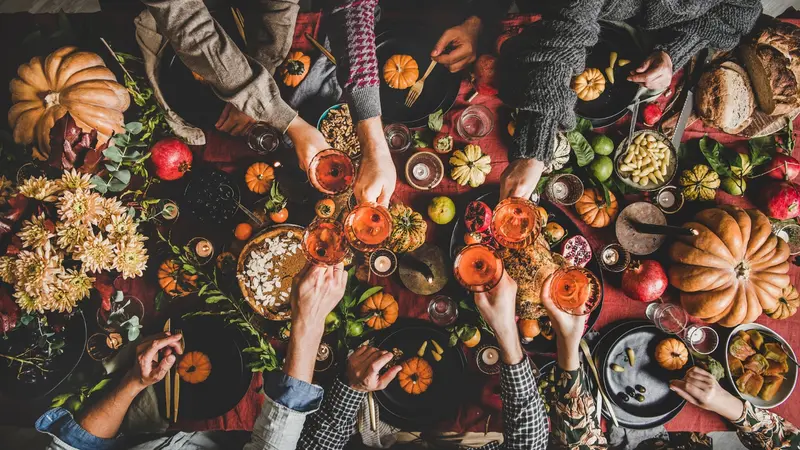 Family or friends celebrating Thanksgiving day clinking glasses with champagne