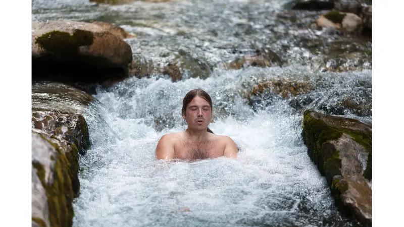 Man sitting in cold river water