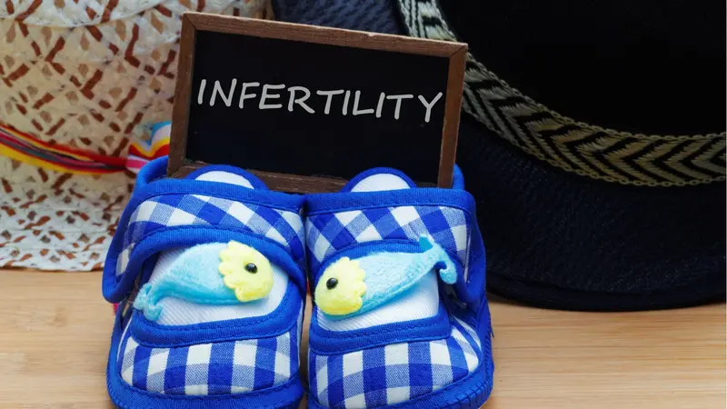 Infertility concept with blue baby shoes