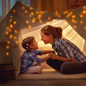  mother and daughter playing at home in a tent