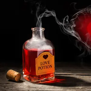 Love potion is red in a bottle. The fragrance of the elixir evaporates and draws from the smoke a heart symbol.