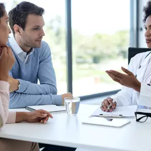 Female doctor counseling a couple.  Drazen Zigic/Shutterstock  