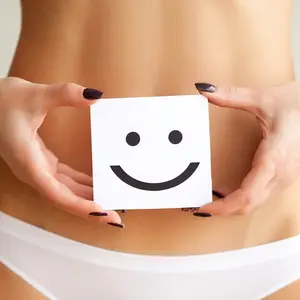 Woman holding paper with smile mark over her stomach