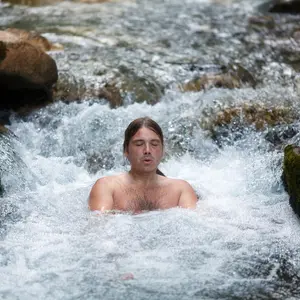 Man sitting in cold river water