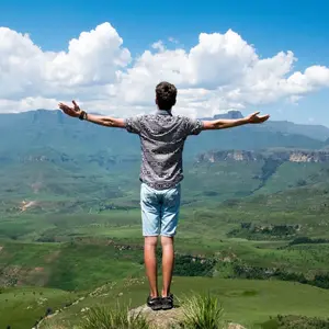 Freedom, man with outstretched arms looking over valley Freedom, man with outstretched arms looking over valley