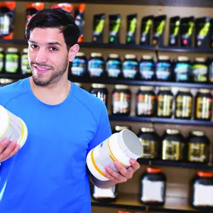 A man holding a supplement powder jars A man holding a supplement powder jars