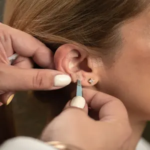 Woman receiving auricular acupuncture Woman receiving auricular acupressure
