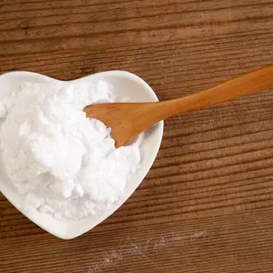 Backing soda in a heart-shaped bowl and wooden spoon Backing soda in a heart-shaped bowl and wooden spoon