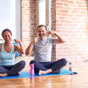 Woman and man doing yoga and pointing to their teeth Woman and man doing yoga and pointing to their teeth