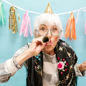 Older woman celebrating with a paper horn Older woman celebrating with a paper horn