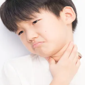 Boy holding his throat in pain, PANDAS arises from complications after strep throat Boy holding his throat in pain, PANDAS arises from complications after strep throat